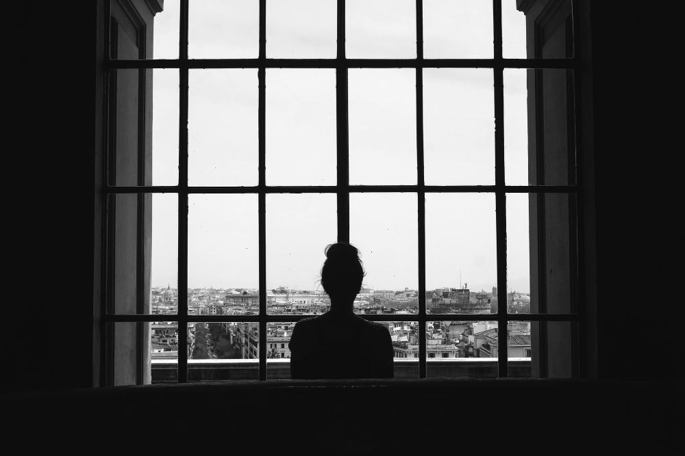 Mujer de espaldas mirando por ventanal grande